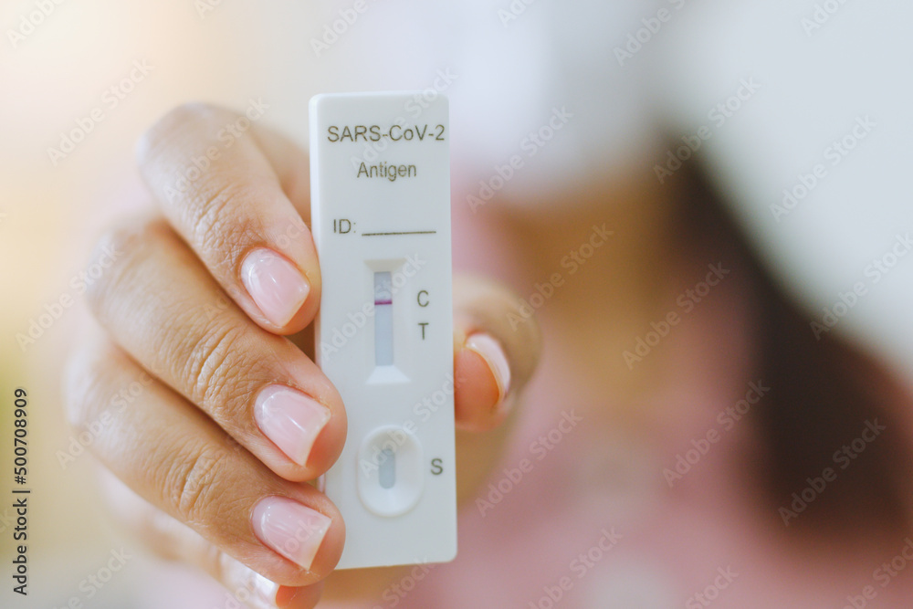 Young Asian woman using rapid antigen test kit (ATK) for self test at home. Show negative result. Pandemic of disease, covid-19, coronavirus Young Asian woman using rapid antigen test kit (ATK) for self test at home. Show negative result. Pandemic of disease, covid-19, coronavirus
