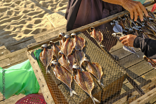 selling sun-dried fish on wooden racks on the beach in Nazaré, Portugal