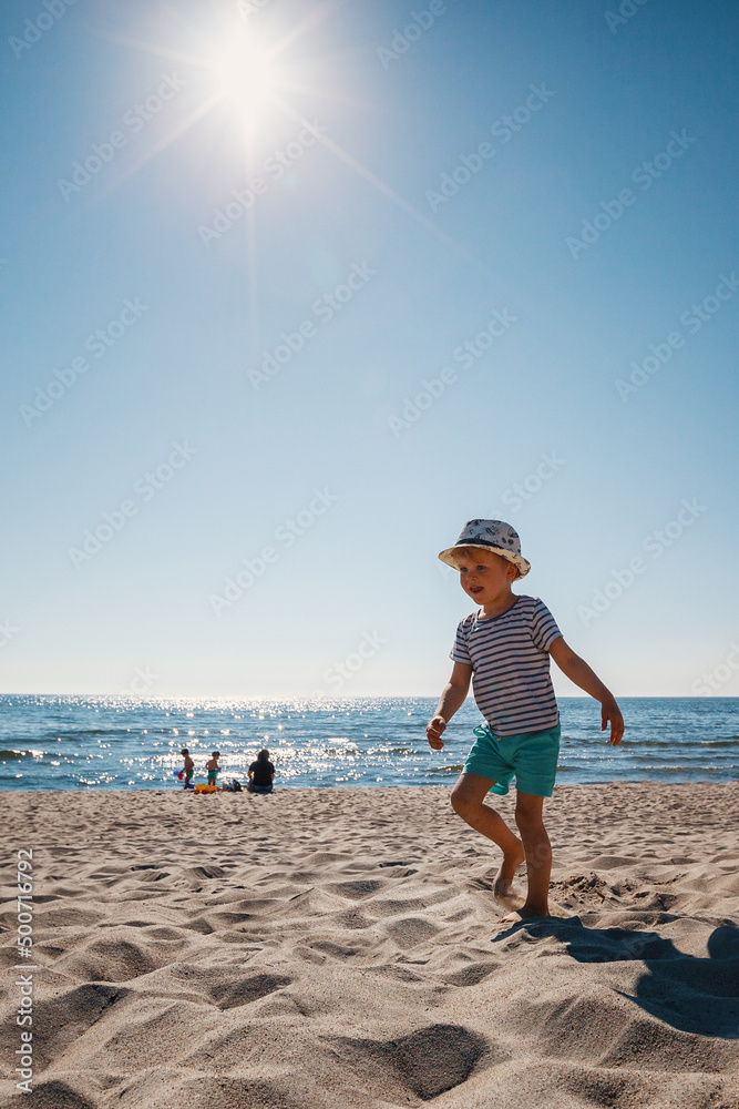 Child walking on a beach. Summer family vacation at Baltic sea, Lithuania.