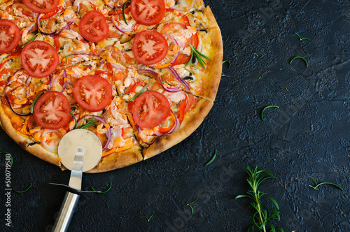 Vegetarian pizza, on a black concrete background. Pizza with tomatoes and cheese, and vegetables, no meat, top view with copy space