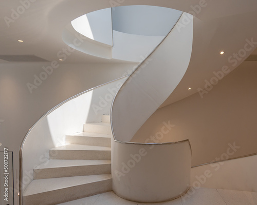 Modern spiral staircase architecture building is a beautiful design and makes the most of limited spaces for an office building with light and shadow and color shade.