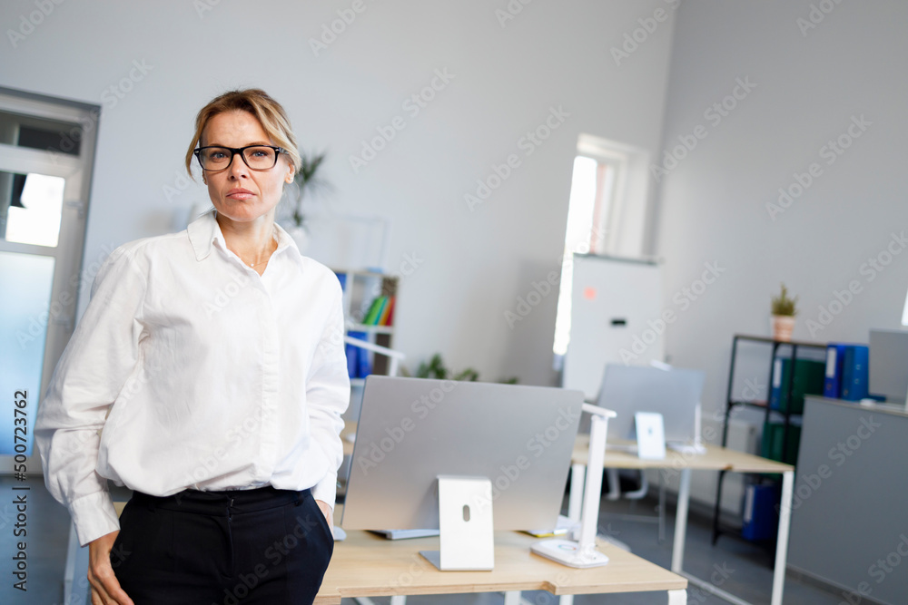 Female boss in white shirt and glasses in the office