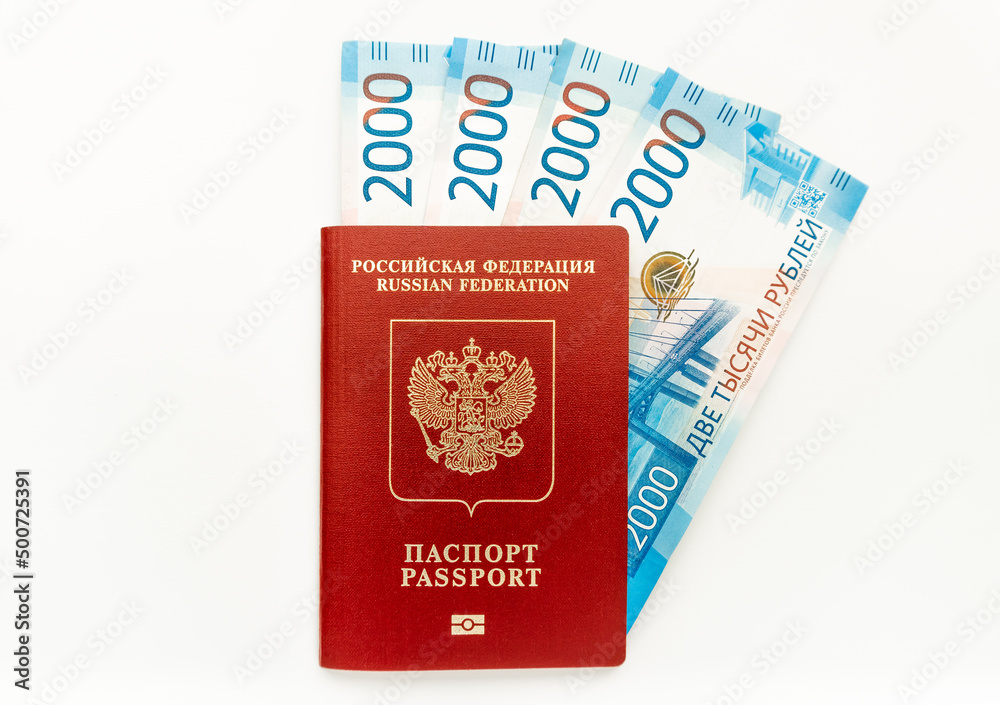 The Russian international passport in red cover with paper money (2000 rubles). White background. Top view. The Russian international passport in red cover with paper money (2000 rubles). White background. Top view.