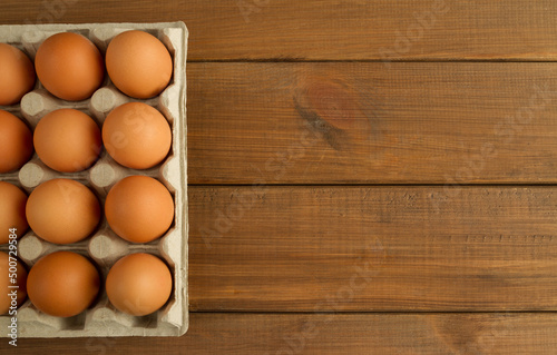 Fresh eggs in pulp carton, cardboard packaging container. Flat lay composition with copy space on wooden panel planks background.
