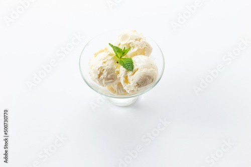 Three scoops of ice cream in a glass bowl. On a white background.