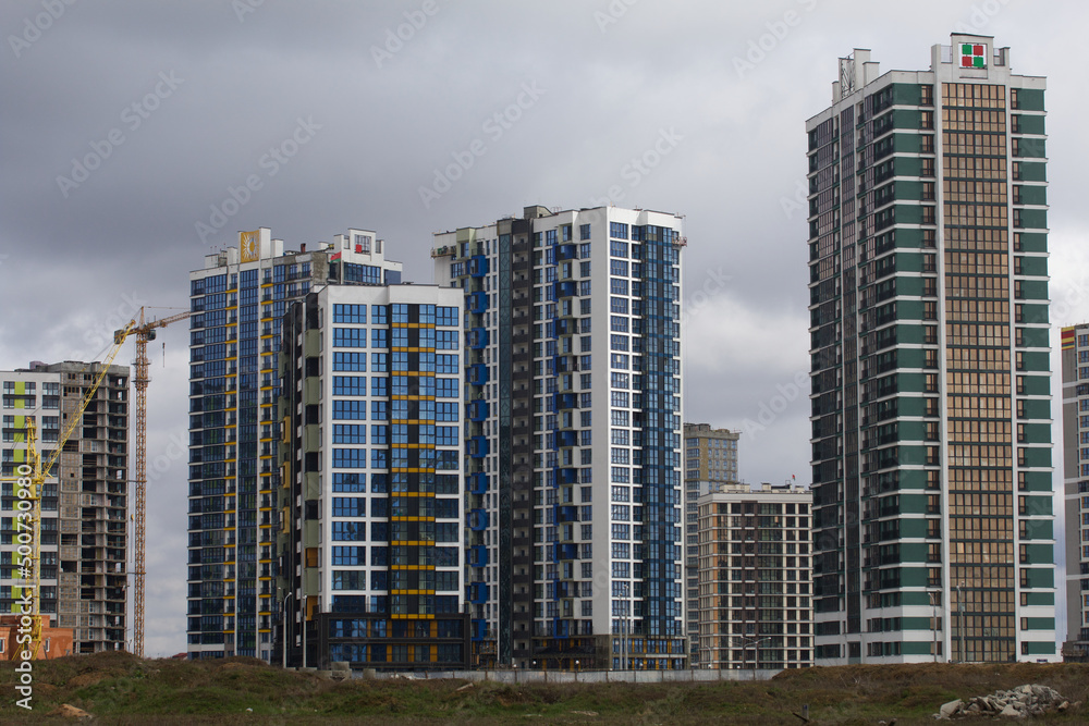 Construction of multi-storey buildings. Modern multi-storey building. Completed and under construction buildings. Construction cranes are visible. Construction of multi-storey buildings. Modern multi-storey building. Completed and under construction buildings. Construction cranes are visible.