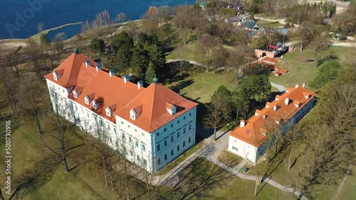 Aerial Shot of Birzai Castle, Fortress Birzai - a Castle in Birzai, on the Southern Coast of the Lake Širvėna in Lithuania, Sunny Spring Day. Historic Beautiful Church and Birzai City Panorama 4K UHD  photo