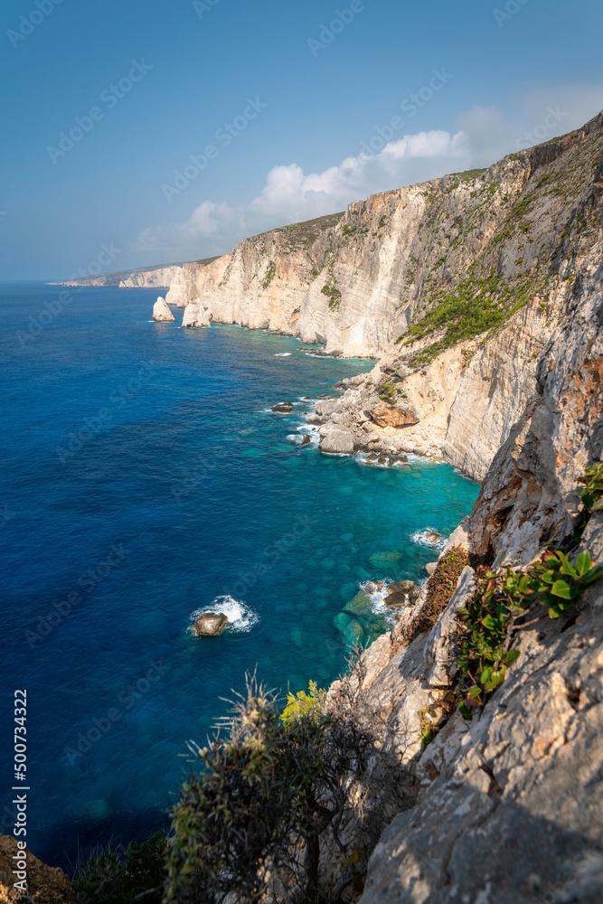 Famous cliff rock, sea, celar blue water, nature in Zakynthos Ionian island, Greece. Amazing view with multicolored clouds, clear sky. Island of lovers. Doors to heaven.