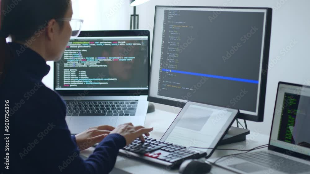 Young Asian woman, developer programmer, software engineer, IT support, wearing glasses working on computer to check coding in bugging system. Back view