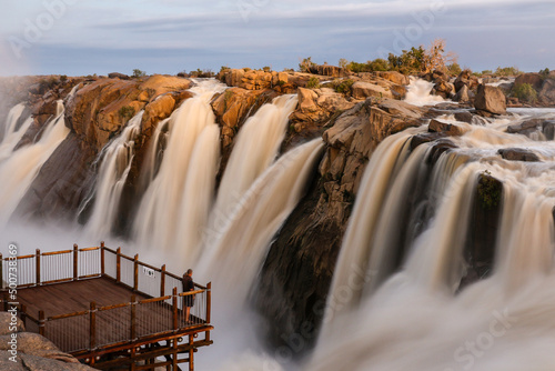 Fototapeta Naklejka Na Ścianę i Meble -  Slow exposure of Augrabies waterfall in South Africa with a visitor on the viewing platform