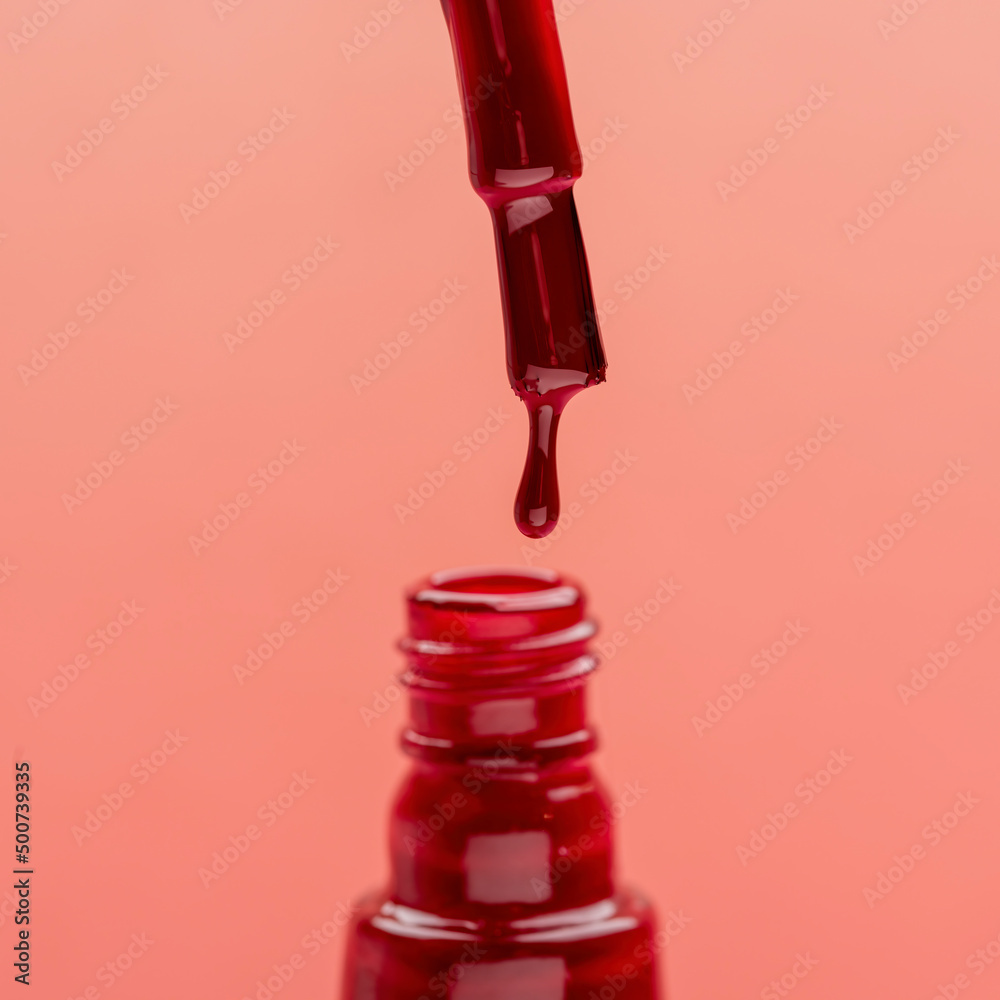 nail brush with red lacquer on pink background nail brush with red lacquer on pink background
