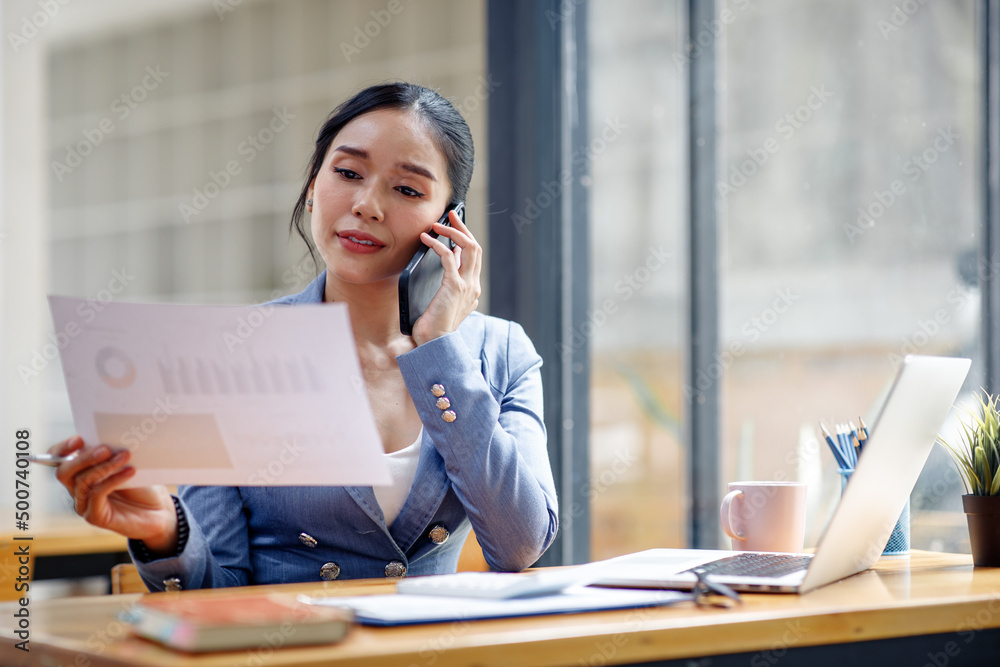Asian Businesswoman Using laptop computer and working at office with calculator document on desk, doing planning analyzing the financial report, business plan investment, finance analysis concept. Asian Businesswoman Using laptop computer and working at office with calculator document on desk, doing planning analyzing the financial report, business plan investment, finance analysis concept.