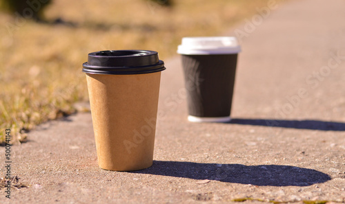 A close-up two brown cardboard disposable coffee cups. A place for your packaging design.