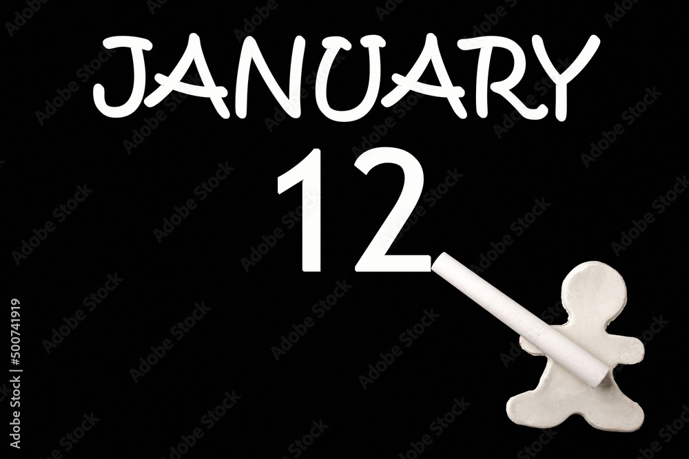 A small white plasticine man writing the date 12 January on a black board. Business concept. Education concept. A small white plasticine man writing the date 12 January on a black board. Business concept. Education concept.
