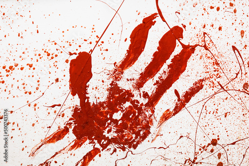 Red painted handprint with splashes on white background. Surface with print of bloody human palm and fingers. Horror, crime, mysticism concept. Backdrop for halloween. © Avalepsap
