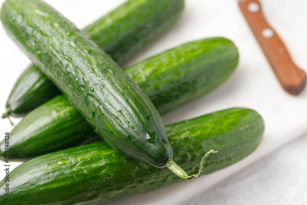 Four Cucumber with water drop on marble board with knife. Food preparing Four Cucumber with water drop on marble board with knife. Food preparing