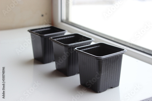 Empty plastic containers for gardening. Pots for seedlings on the windowsill.