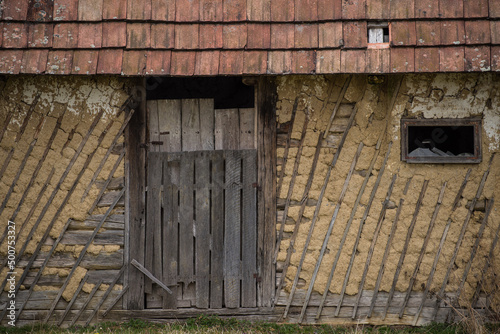Croatia, April 20,2022 : Facade of mud and straw on old wooden house.