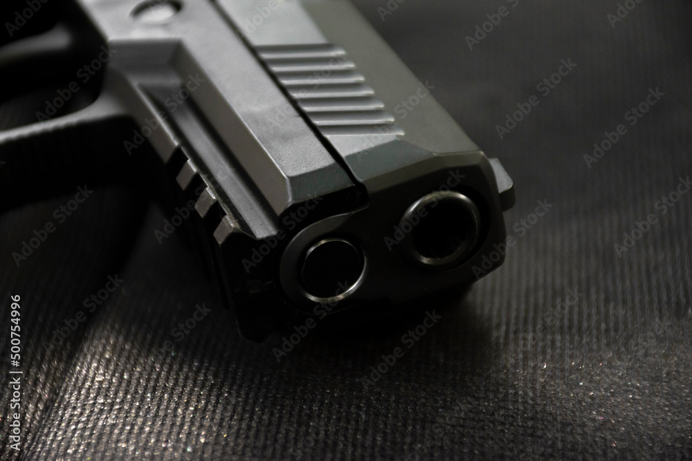 Automatic 9mm pistol gun on black leather background, soft and selective focus. Automatic 9mm pistol gun on black leather background, soft and selective focus.