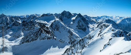 Panoramic view of wild mountain landscape in winter. Snowy rocky mountains under blue sky. Stubai Alps, Tirol, Austria, Europe