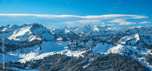 Panoramic view of mountain landscape in winter. Snow covered rocky mountains under blue sky. Vorarlberg, Austria, Europe