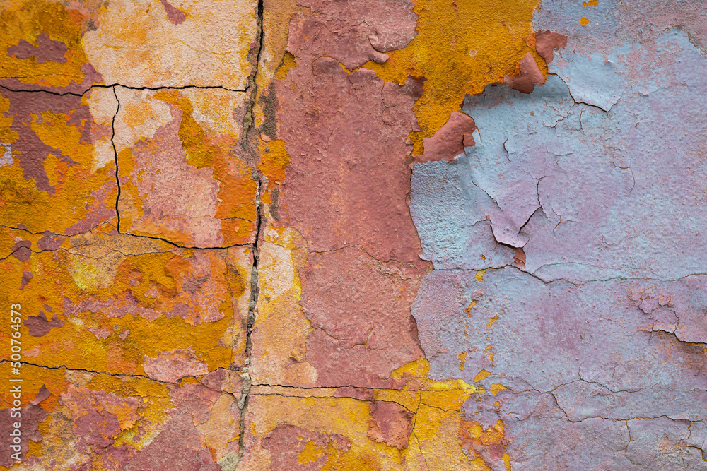 Multicolour shabby concrete wall with flaky plaster. Vintage, cracked distressed background. Abstract painting colorful backdrop. Abstract pattern. Cracked painted texture of dilapidated building.
