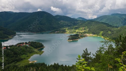 Time-lapse of clouds over lake Zaovine among green hills. Shot in National park Tara in Serbia.  photo
