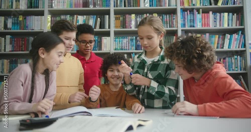 Multinational kids surround boy with kinky hair in library
