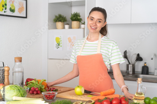 Young vegetarian woman cooking healthy meal at kitchen