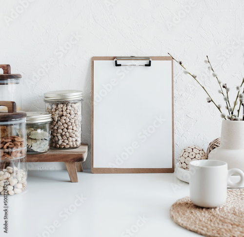 wooden clipboard with blank paper  and modern kitchen utensils table on white backdrop.Trendy Eco style home still life.Space for text or menu . Business food brand template.