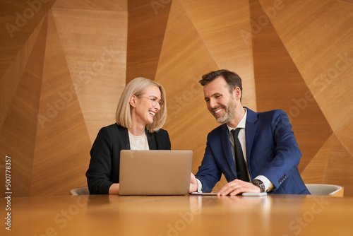 Smiling businesswoman and businessman meeting in conference room at modern office
