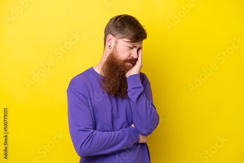 Redhead man with beard isolated on yellow background with headache © luismolinero