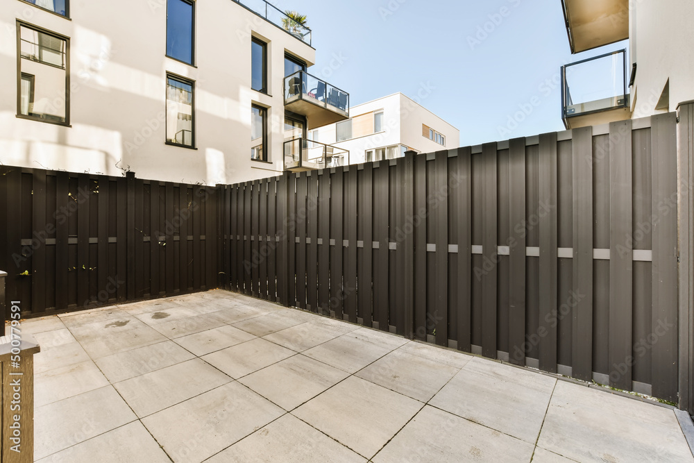 Backyard with terrace with wooden fence against residential house Backyard with terrace with wooden fence against residential house
