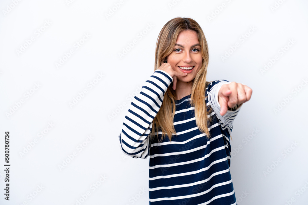 Young Uruguayan woman isolated on white background making phone gesture and pointing front Young Uruguayan woman isolated on white background making phone gesture and pointing front