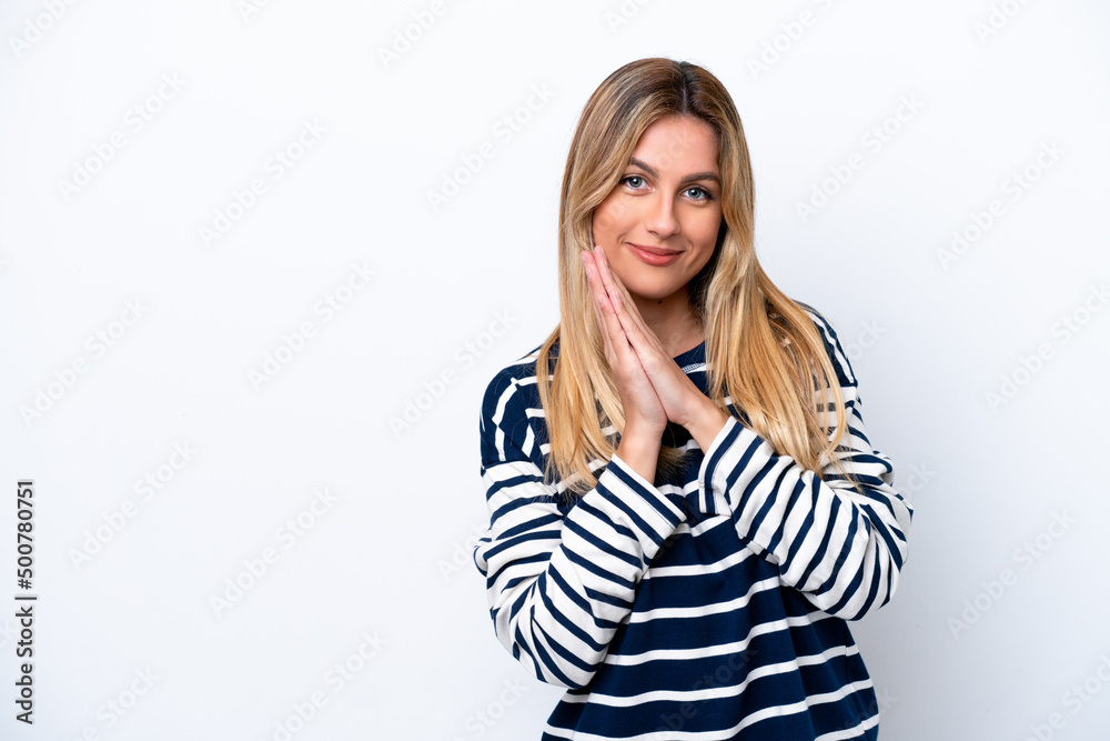 Young Uruguayan woman isolated on white background keeps palm together. Person asks for something Young Uruguayan woman isolated on white background keeps palm together. Person asks for something