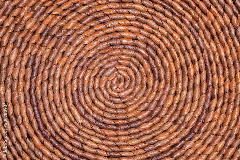 The curled up pattern of brown-colored straw placemat