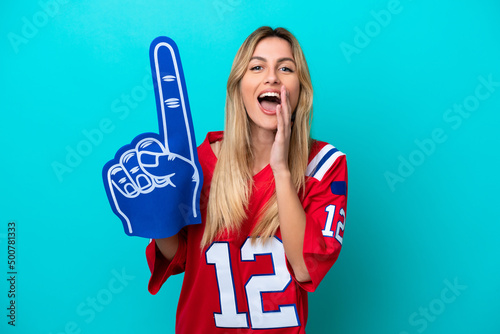 Schilderij op canvas Uruguayan sports fan woman isolated on blue background shouting with mouth wide