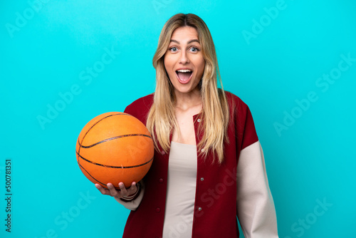 Young caucasian basketball player woman isolated on blue background with surprise facial expression © luismolinero