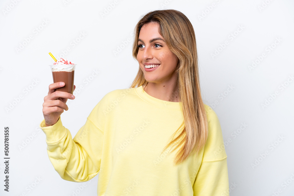 Young Uruguayan woman holding Frappuccino isolated on white background looking side Young Uruguayan woman holding Frappuccino isolated on white background looking side