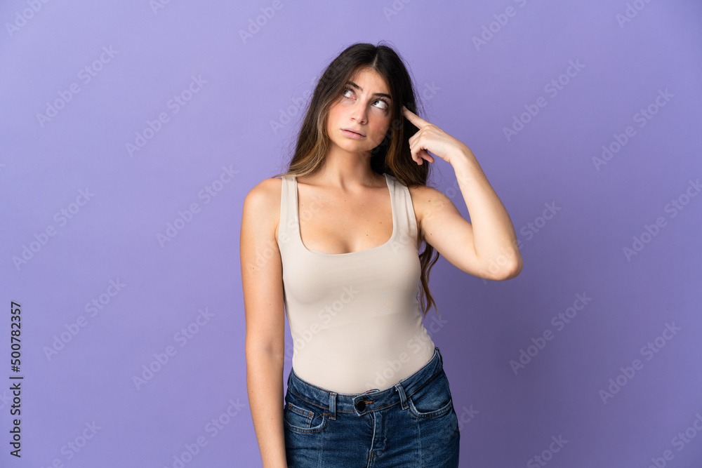 Young caucasian woman isolated on purple background making the gesture of madness putting finger on the head Young caucasian woman isolated on purple background making the gesture of madness putting finger on the head