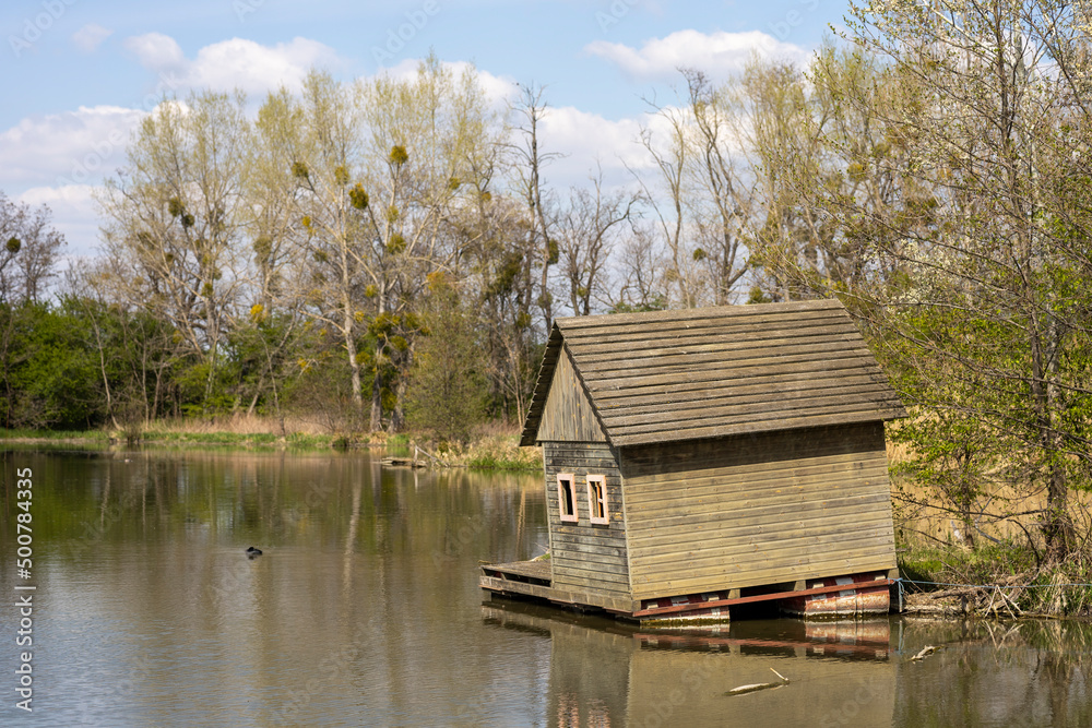 Obraz premium Small wooden house in the forrest, on the river.