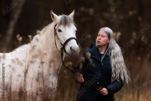 portrait of a young woman with white hair and her white horse