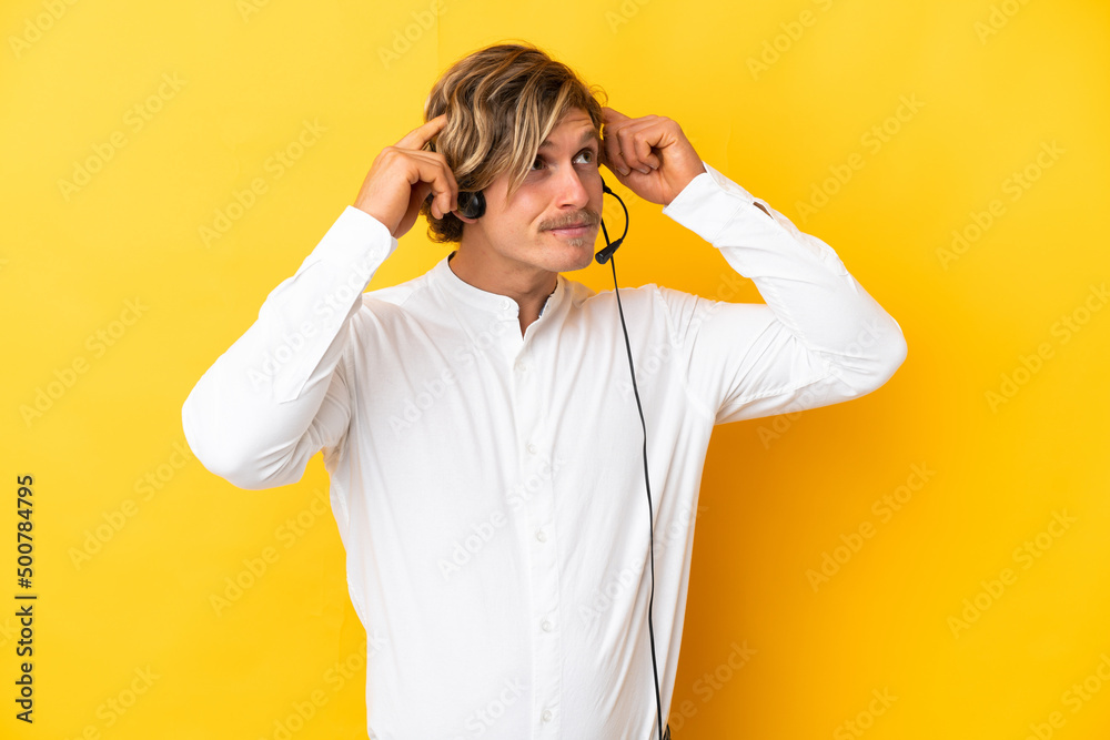 Telemarketer man working with a headset isolated on yellow background having doubts and thinking Telemarketer man working with a headset isolated on yellow background having doubts and thinking