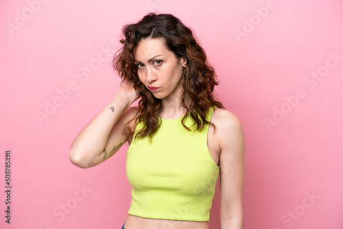 Young caucasian woman isolated on pink background having doubts