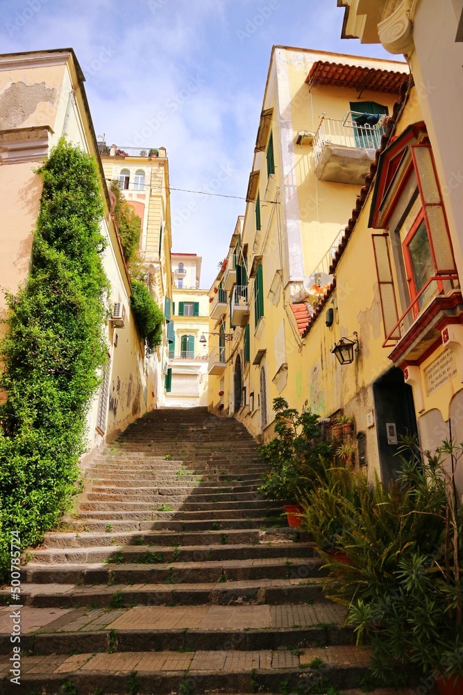 A street between ancient buildings in the historic center of Naples, a city on the Mediterranean in Italy.