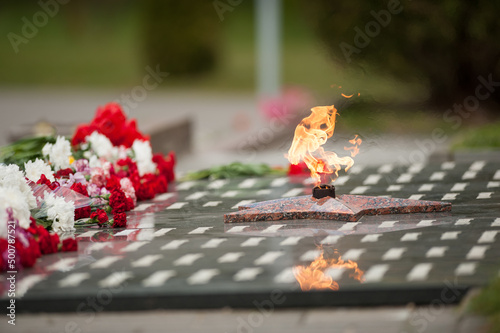 eternal flame and flowers in memory of the fallen soldiers photo