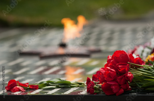 eternal flame and flowers in memory of the fallen soldiers photo