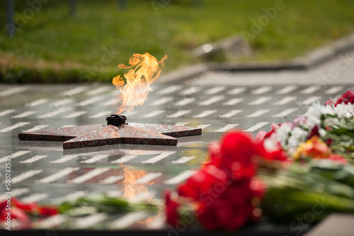 eternal flame and flowers in memory of the fallen soldiers photo