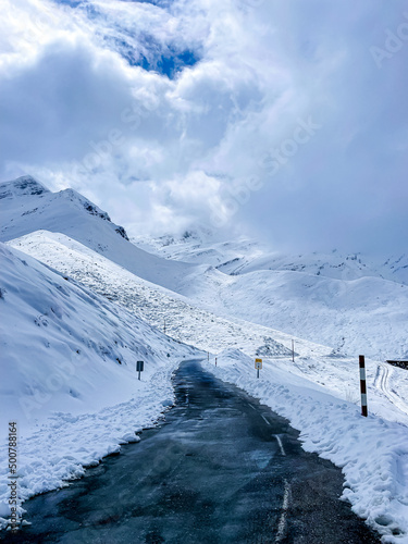 road in the snow between snowy mountains
