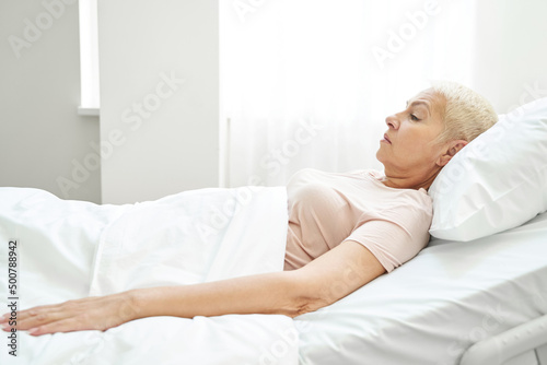 Female pensioner resting in bed ward of medical center